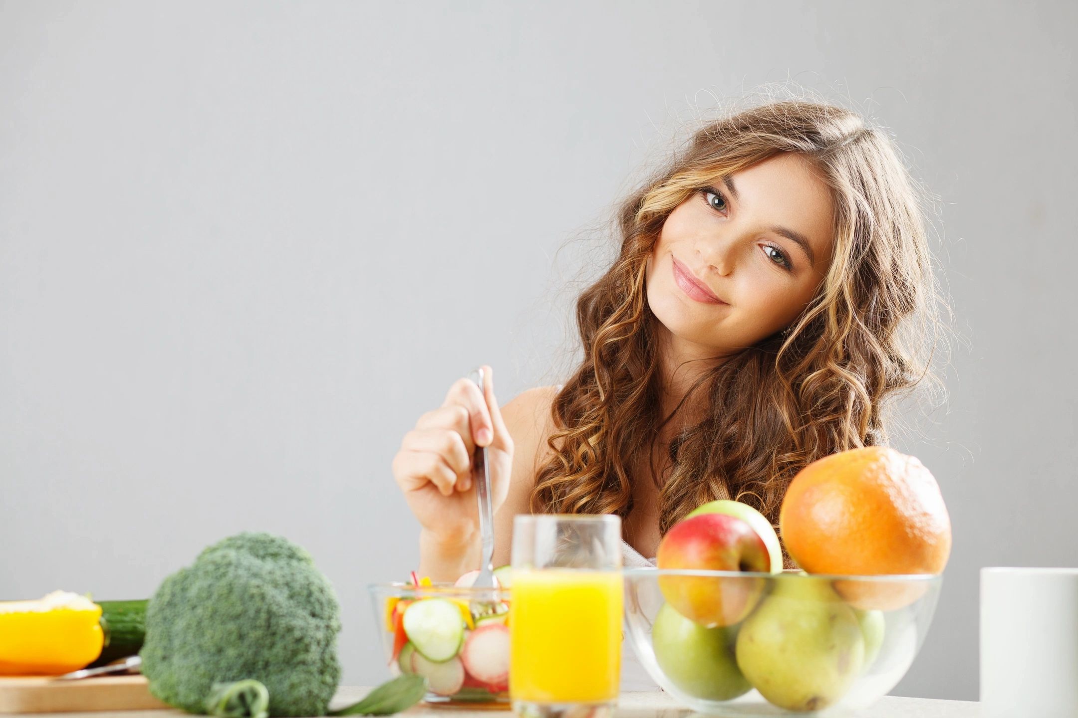 Girl surrounded with fruit and veggies